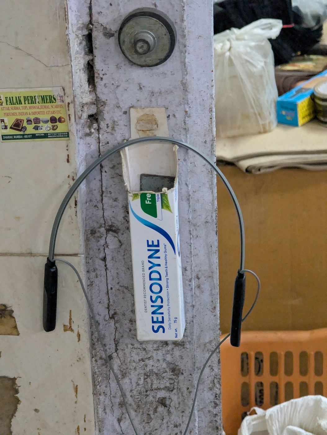 A toothpaste box used to hold cables on a wall