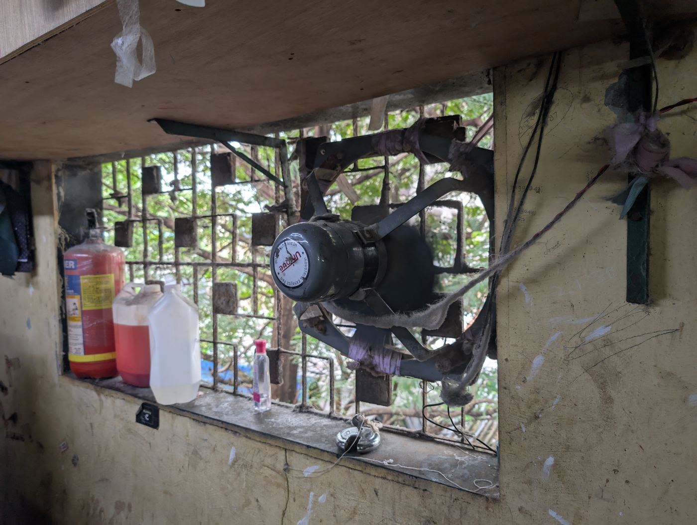 A motor rigged into a barred workshop window